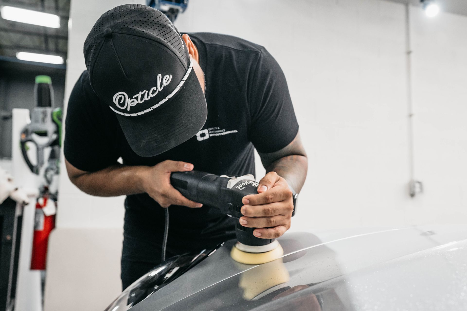 A man is washing a car in a garage.