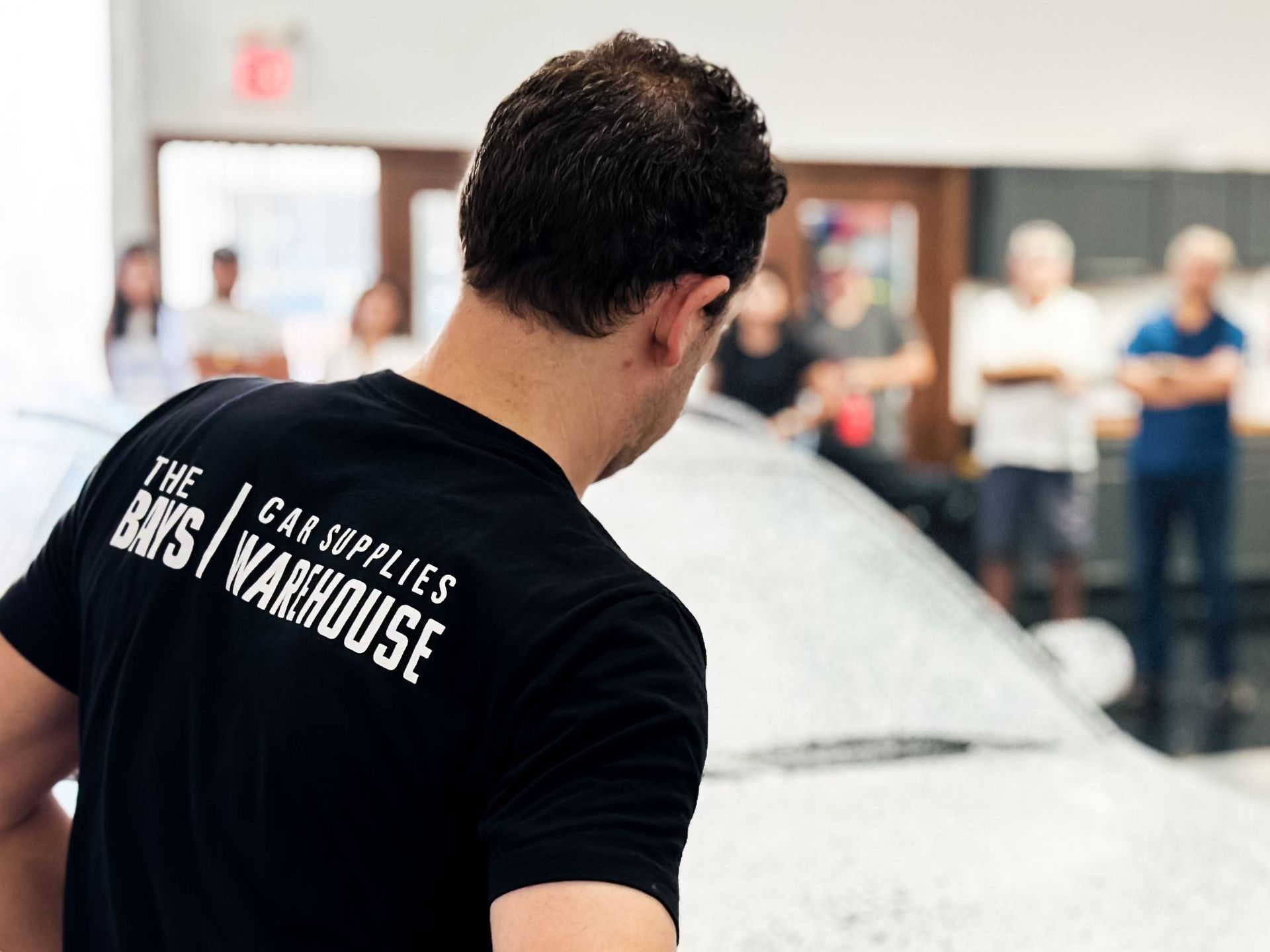 A man wearing a black shirt that says the car supplies days warehouse
