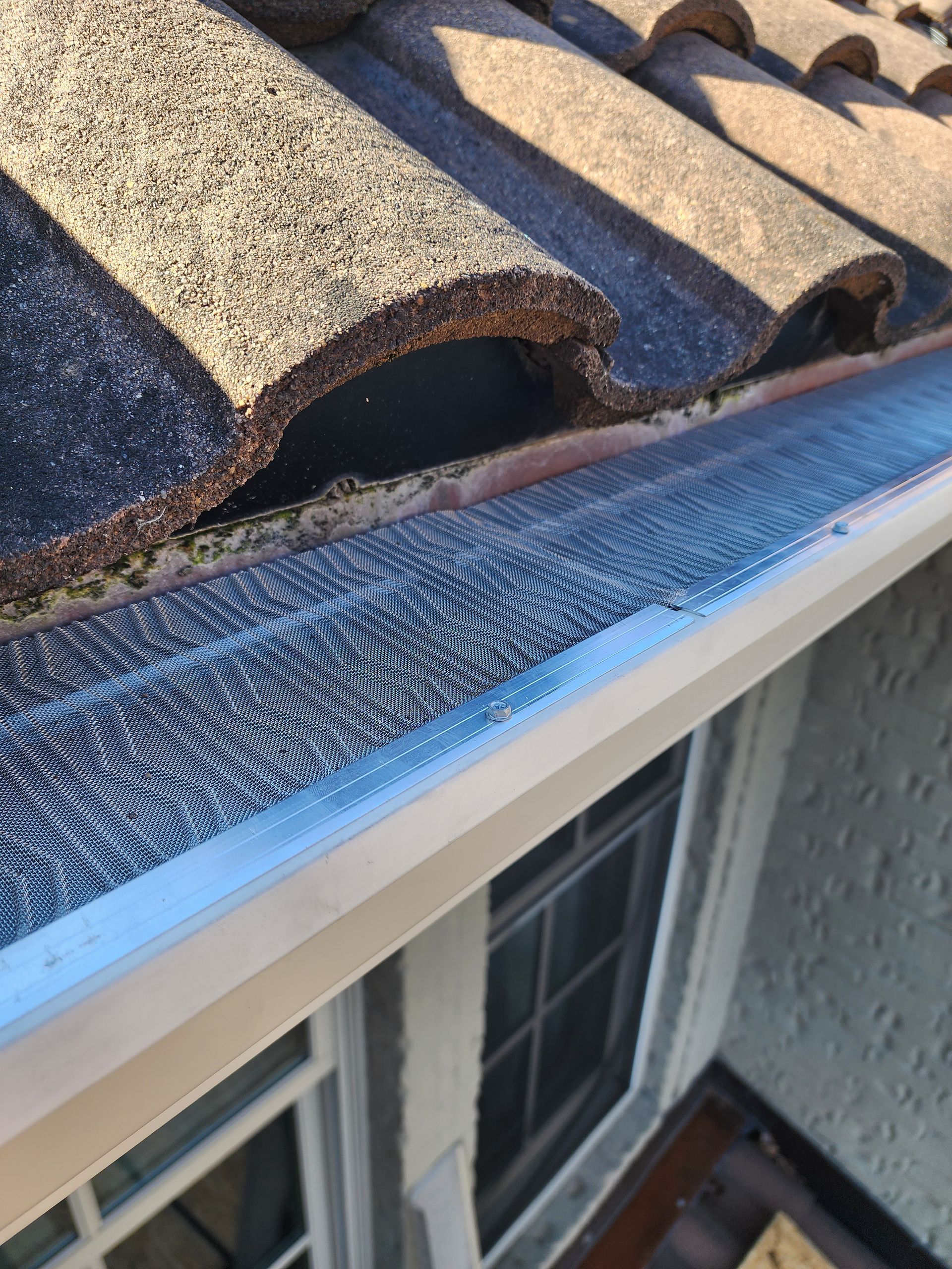 A close up of a gutter on the roof of a house.