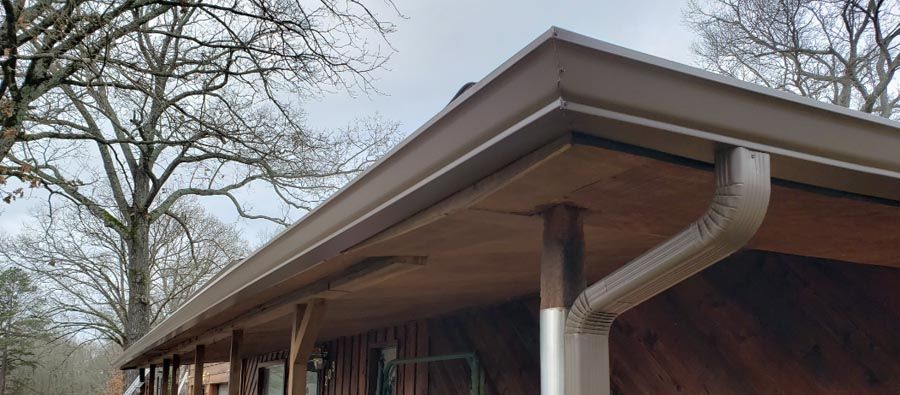 A house with a porch and a gutter on the roof.