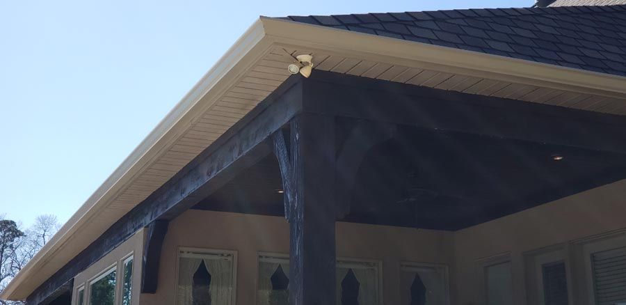 A house with a porch and a black roof.