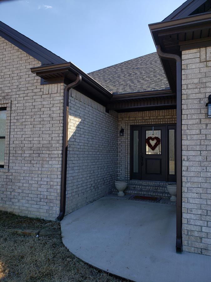 A brick house with a heart hanging on the door.