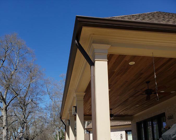 A porch with a gutter and a ceiling fan