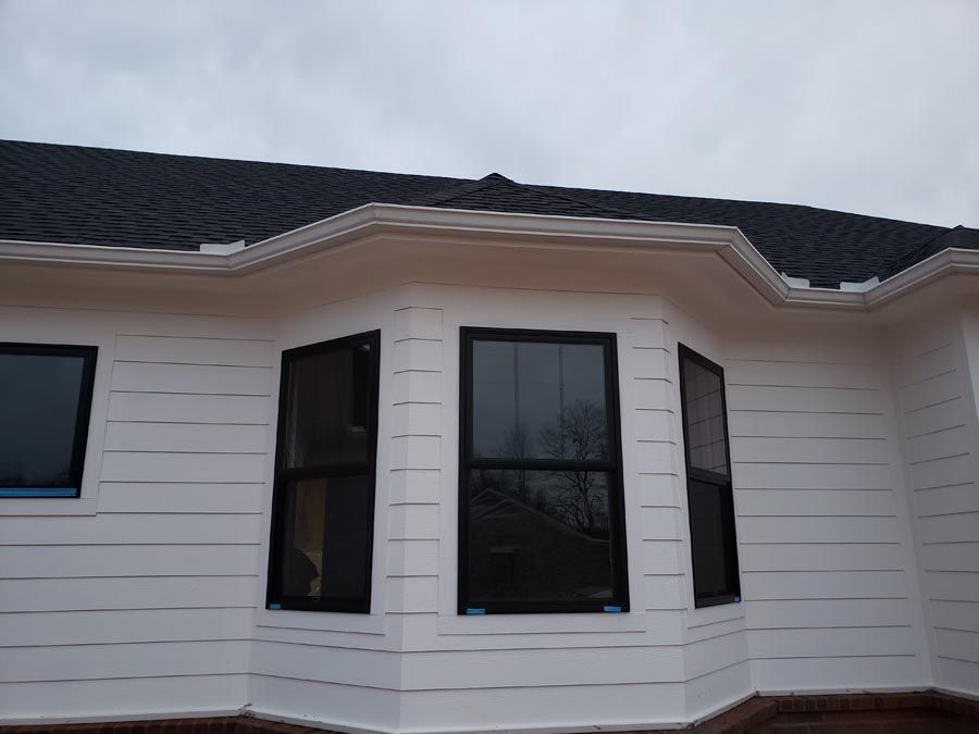 A white house with black windows and a black roof