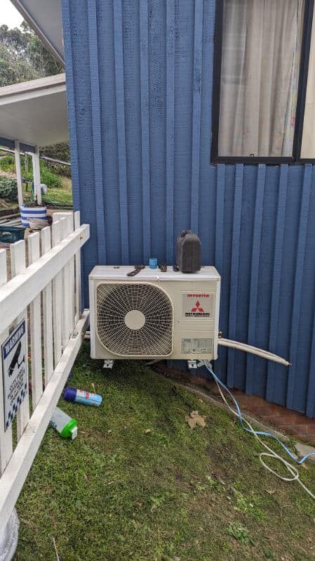 A Mitsubishi Air Conditioning Unit Mounted on a Blue Wall — Escarpment Air in Mount Saint Thomas, NSW