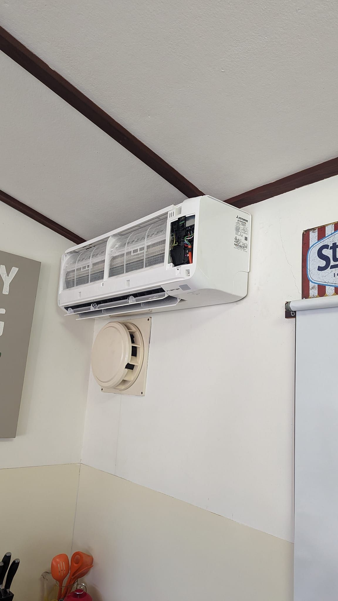 White Wall-mounted Air Conditioner Above a Smoke Detector — Escarpment Air in Mount Saint Thomas, NSW