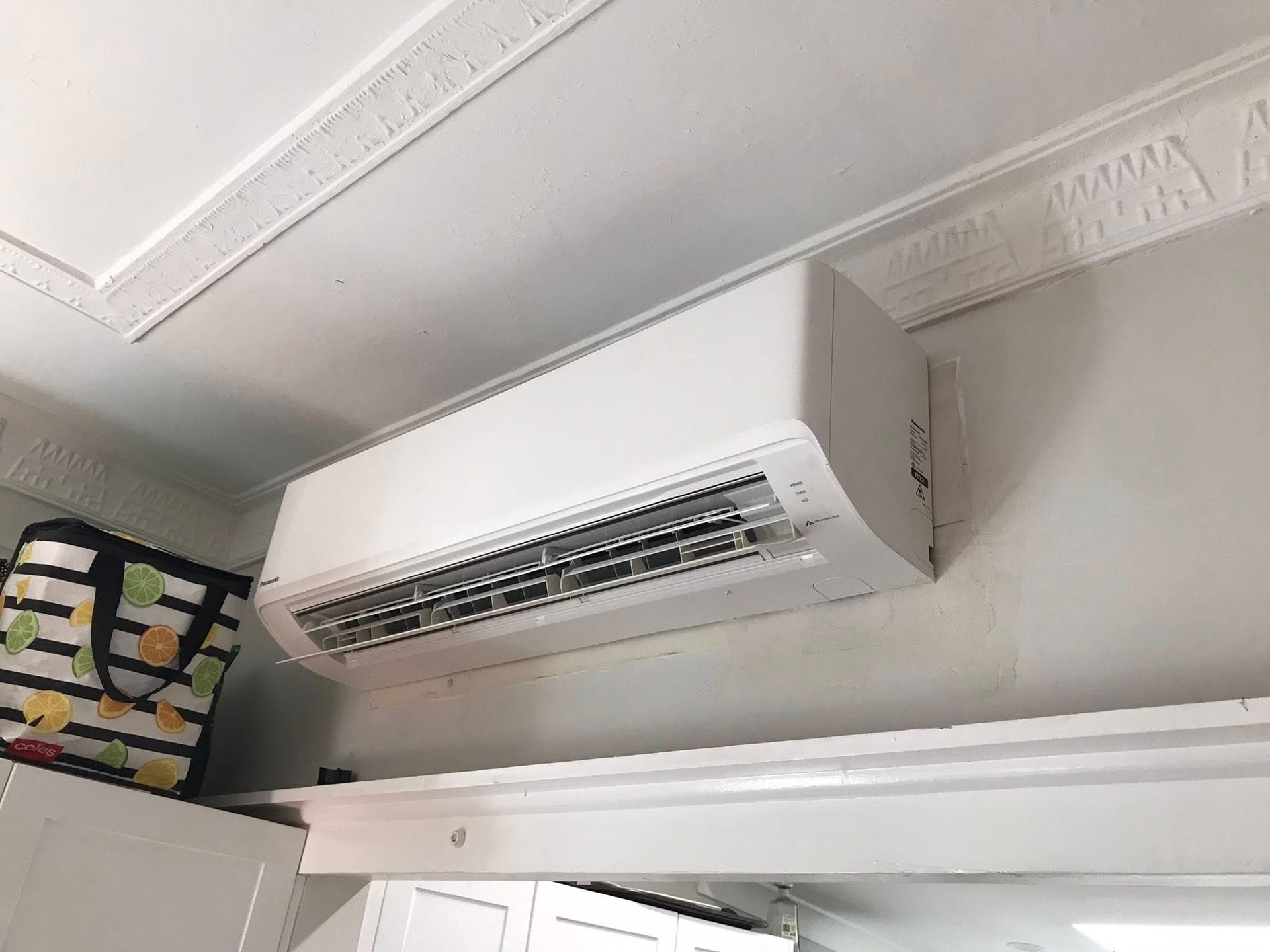 A White Air Conditioner Mounted on a White Wall — Escarpment Air in Mount Saint Thomas, NSW