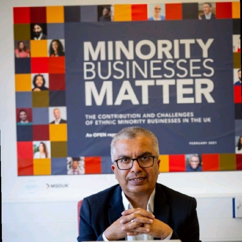 A man sitting in front of a sign that says minority businesses matter