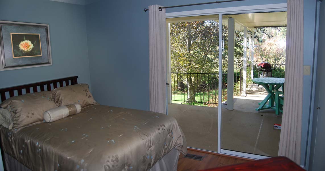 A bedroom with a bed and a sliding glass door