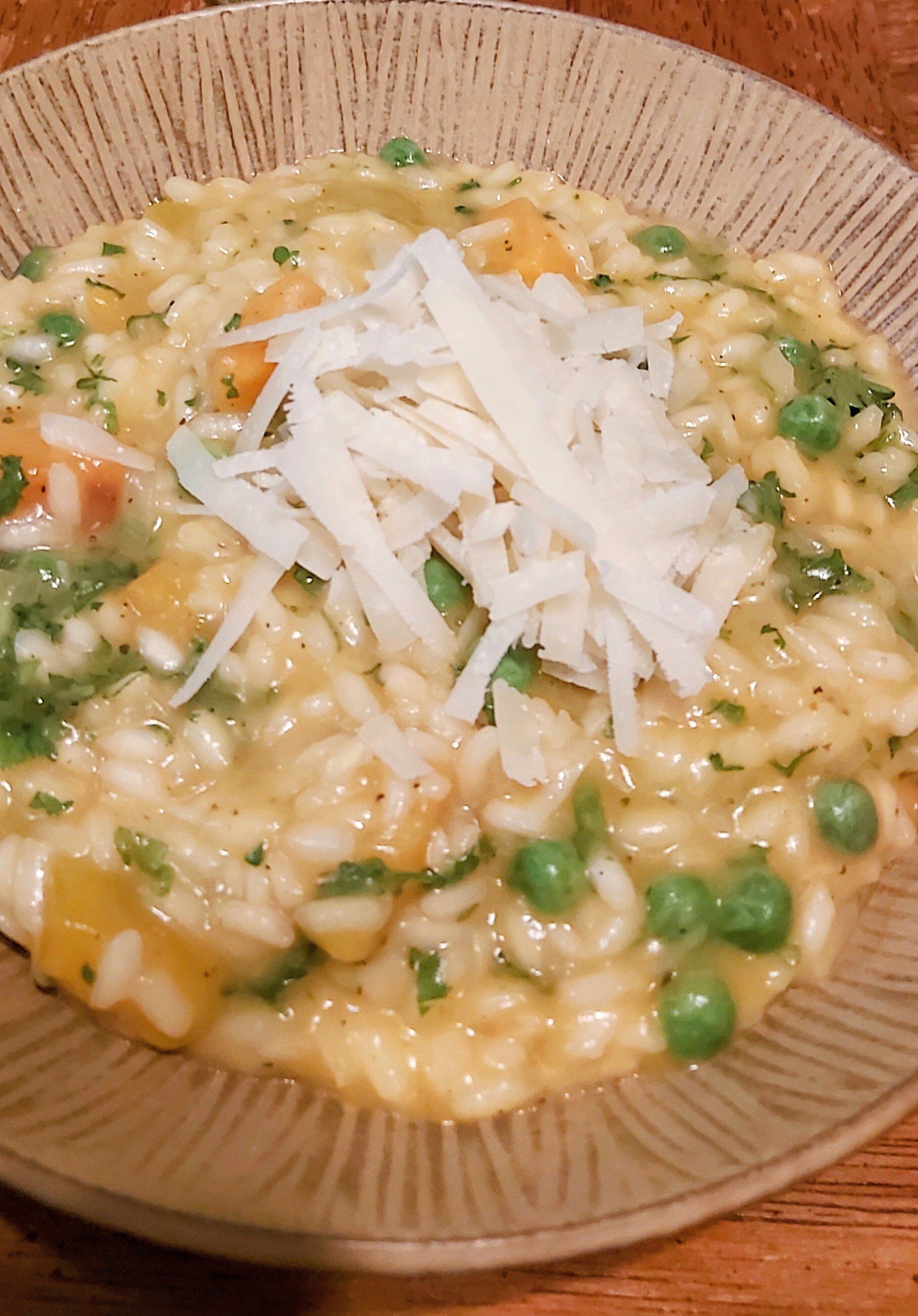 A bowl of rice and peas with cheese on top.