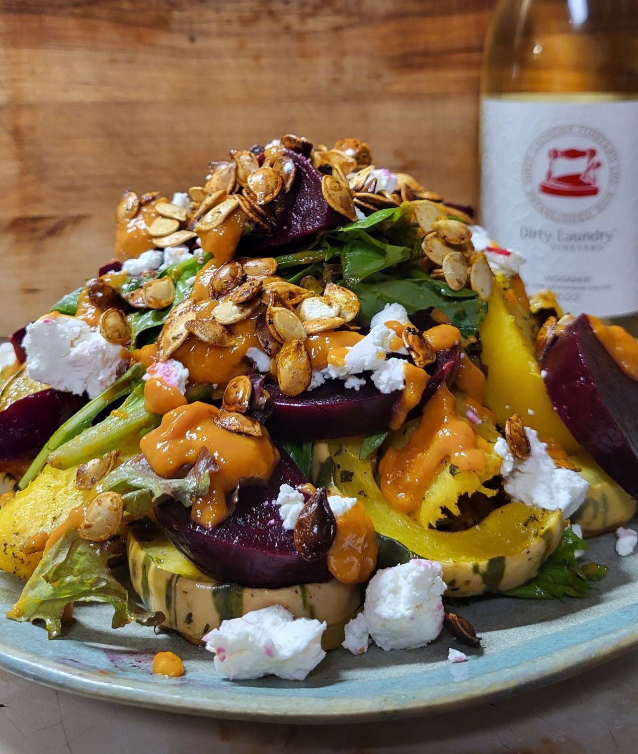 A plate of food with a bottle of wine in the background