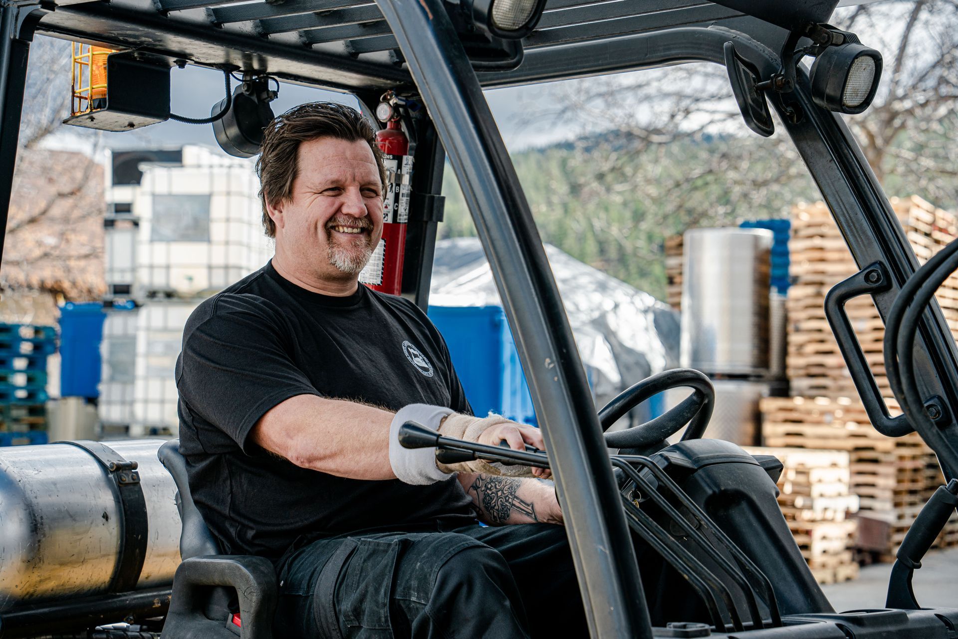 A man is sitting in a forklift and smiling.