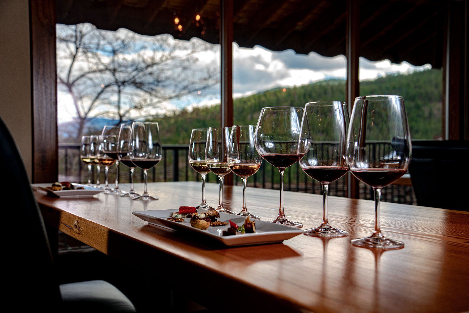 A row of wine glasses sitting on top of a wooden table.