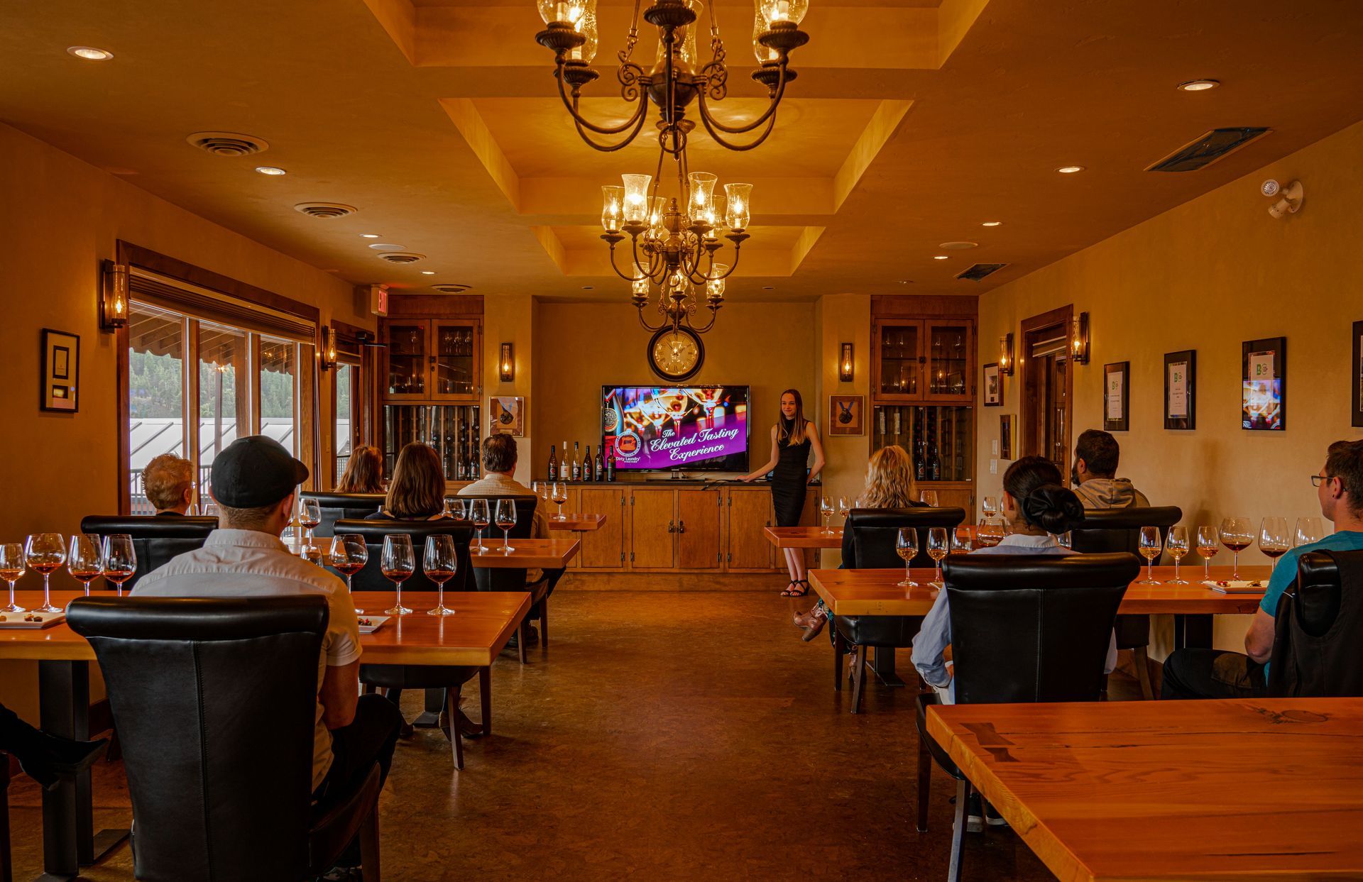 A group of people are sitting at tables in a restaurant watching a television.