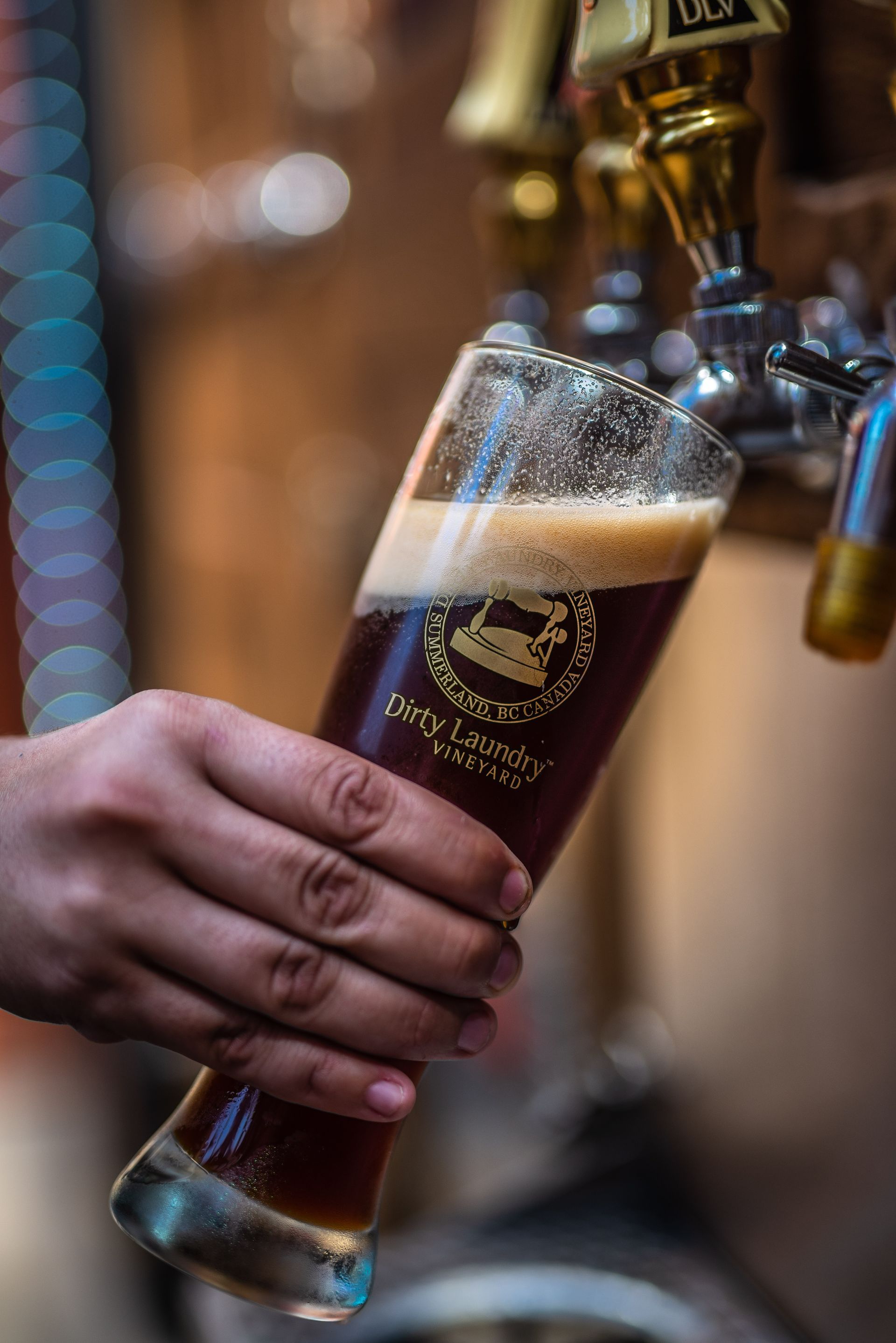 A person is pouring a glass of beer from a tap.