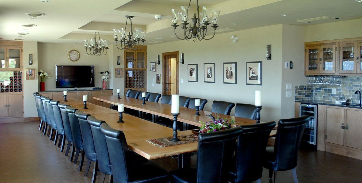 A large dining room with a long table and chairs.