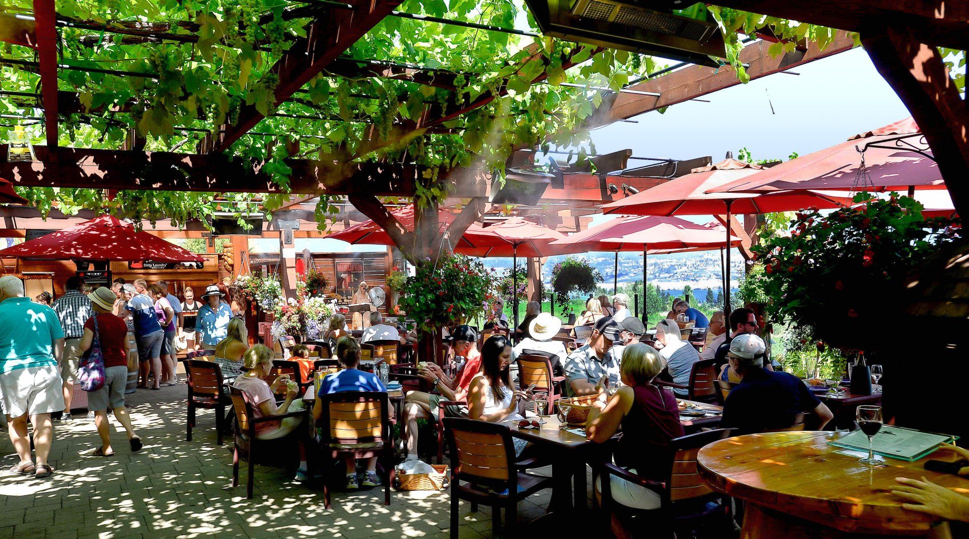 A group of people are sitting at tables in a restaurant under umbrellas.