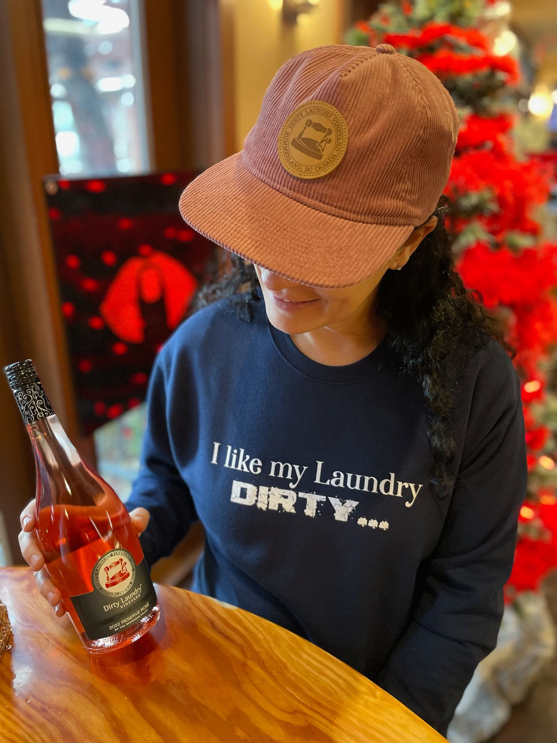 A woman wearing a hat and a sweatshirt that says i like my laundry dirty