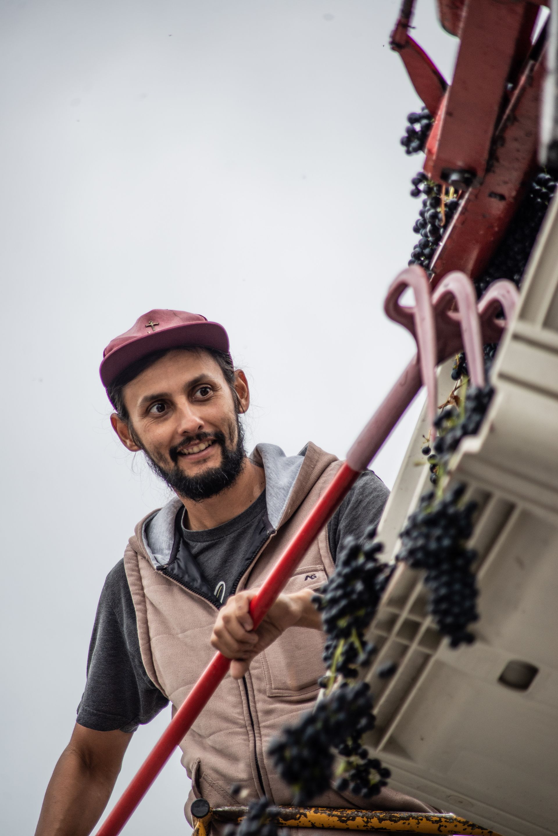 A man with a beard is holding a red stick.