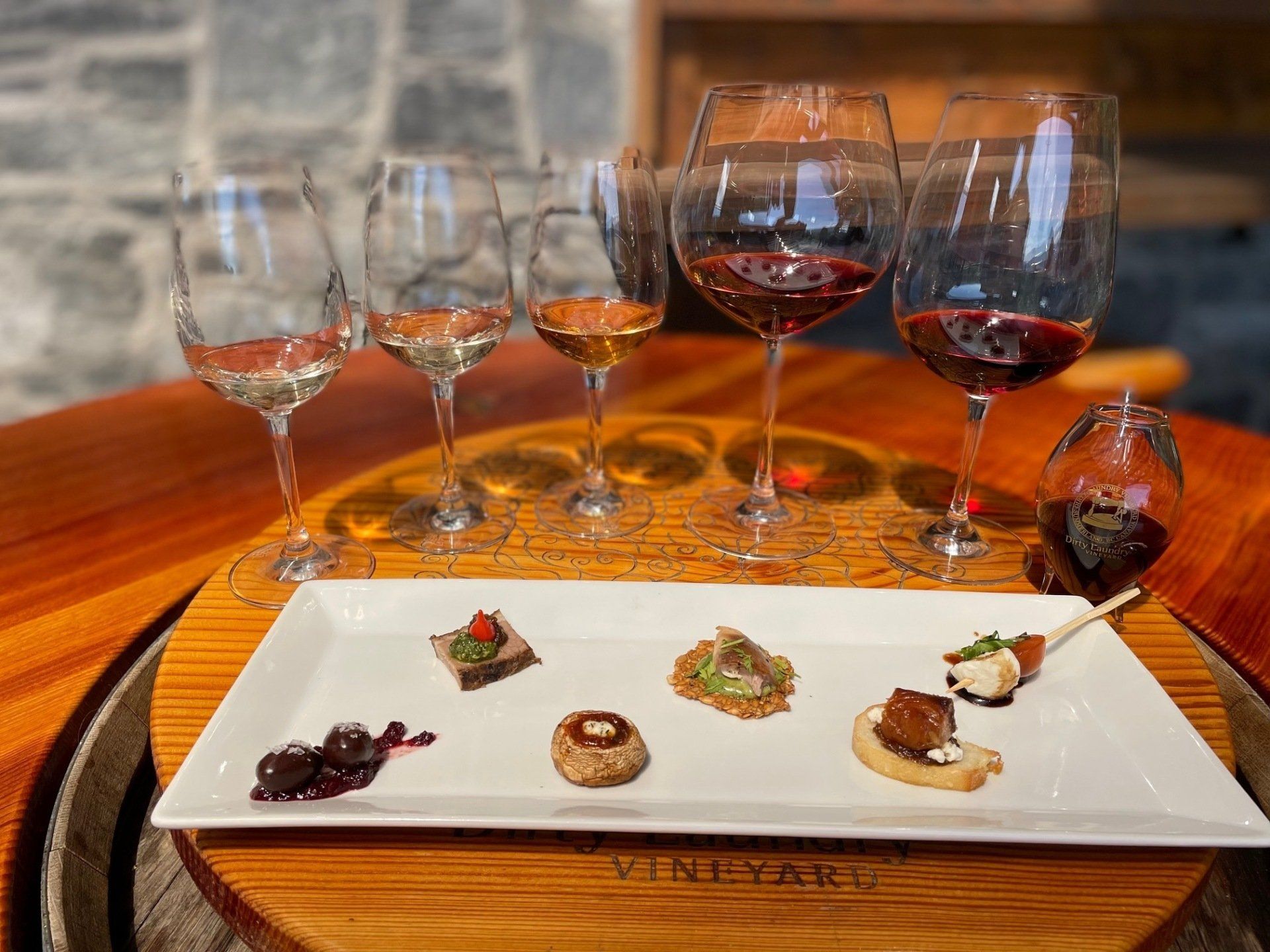 A plate of food and wine glasses on a wooden table.