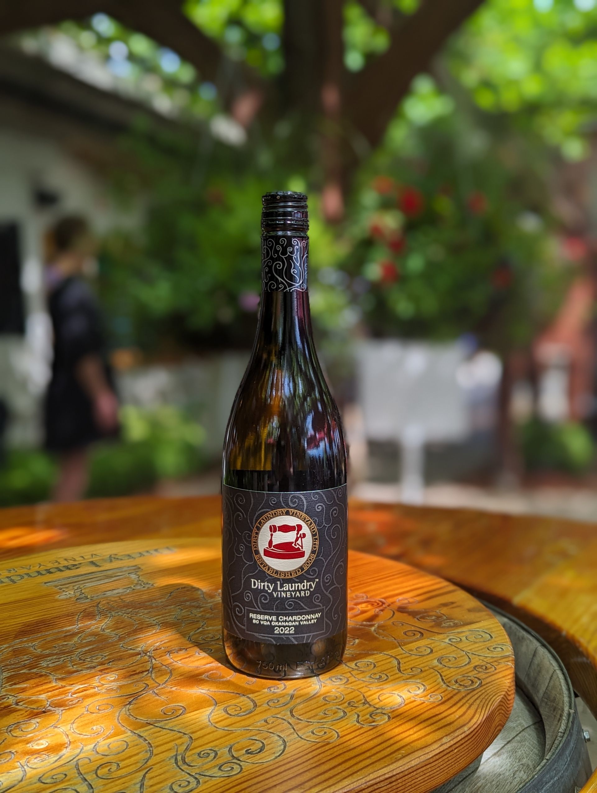 A bottle of beer is sitting on top of a wooden table.
