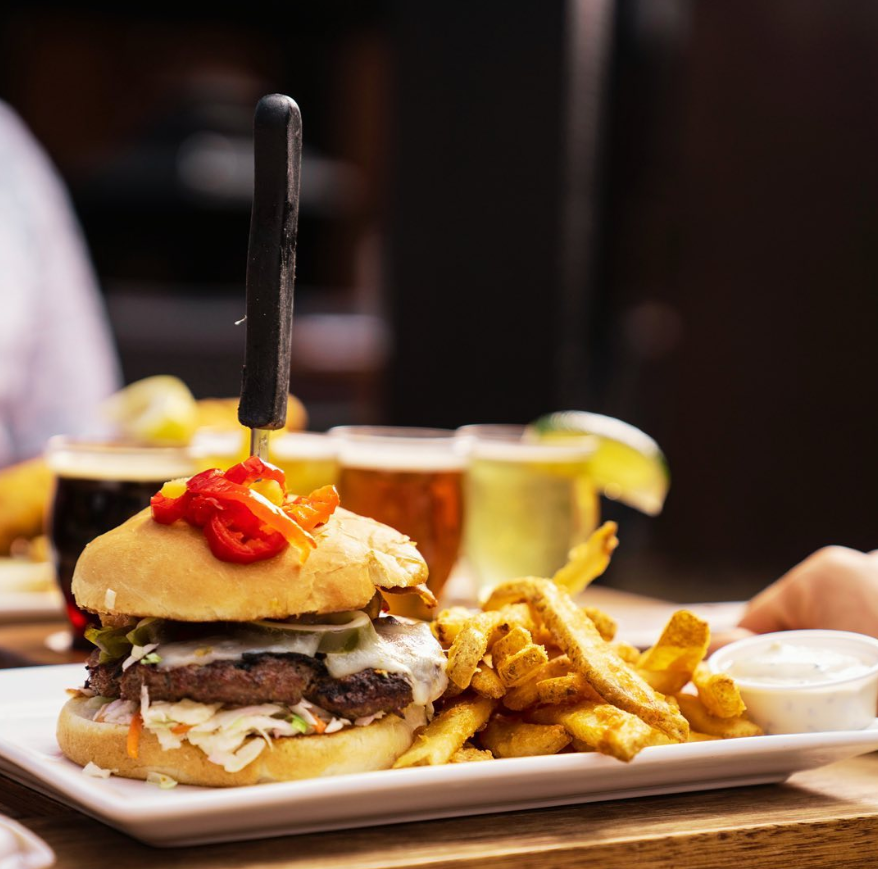 A hamburger and french fries on a white plate on a table.