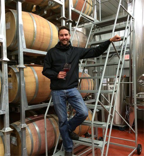 A man standing on a set of stairs holding a glass of wine