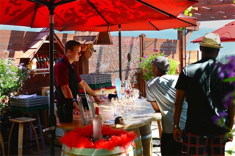 A group of people standing around a table under an umbrella