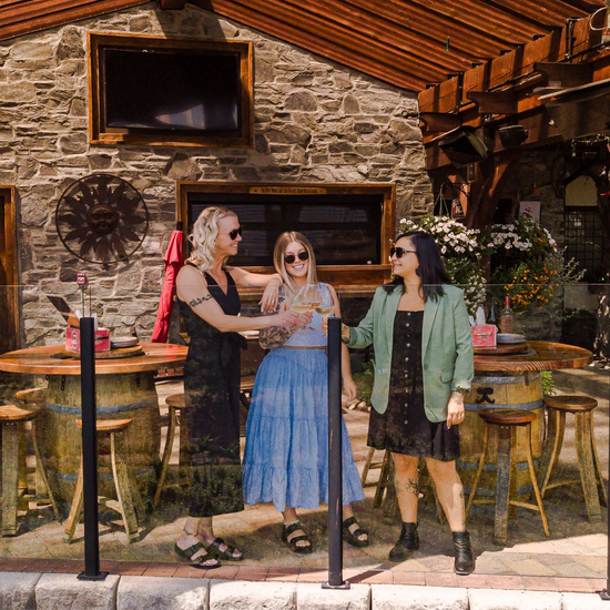 Three people enjoying a wine tasting outside