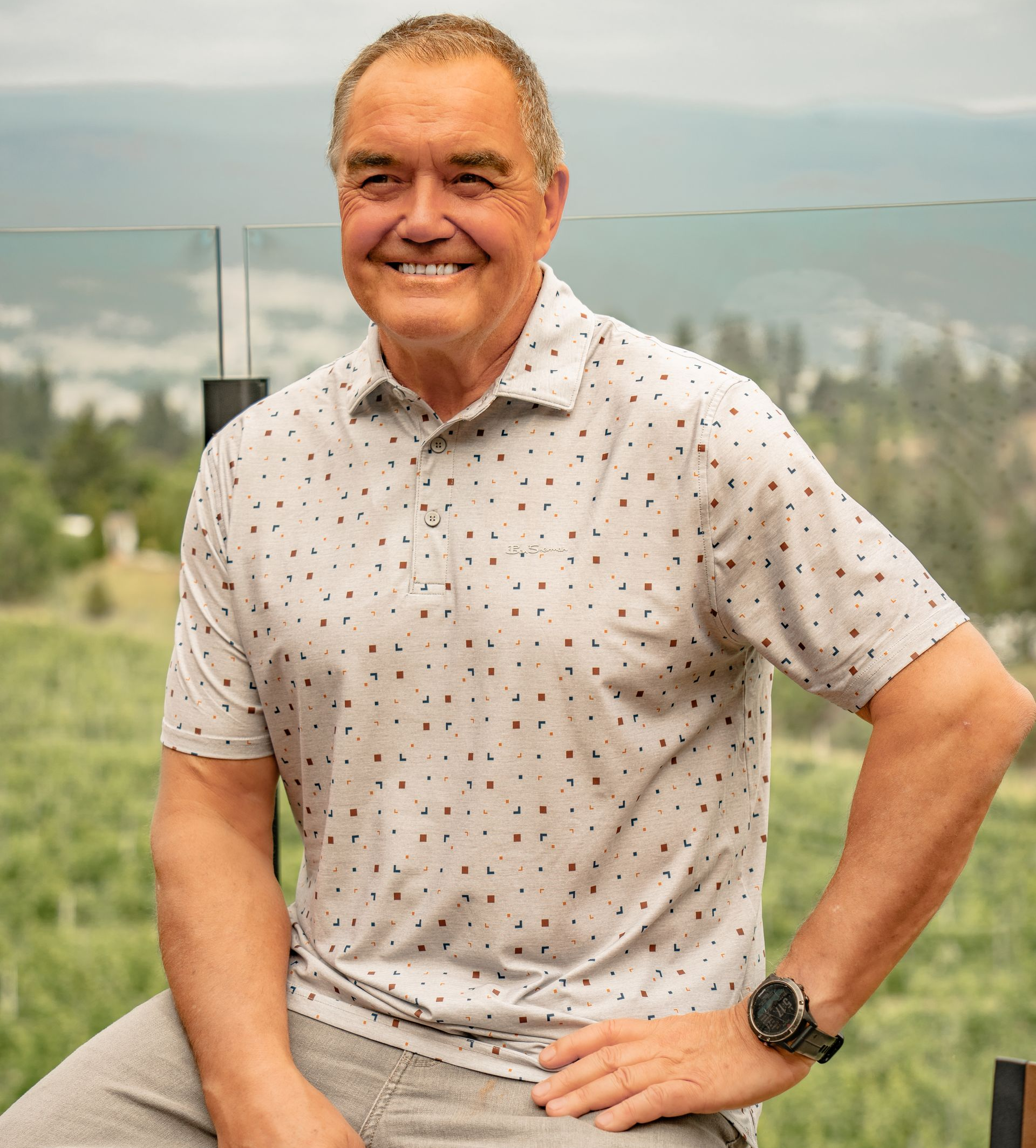 A man in a leather jacket is holding a glass of wine in a snowy field.