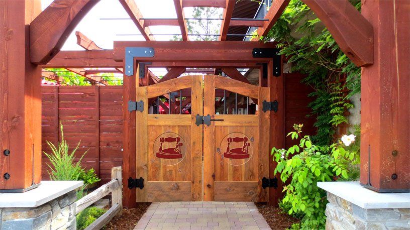 A wooden gate with a pergola in the background
