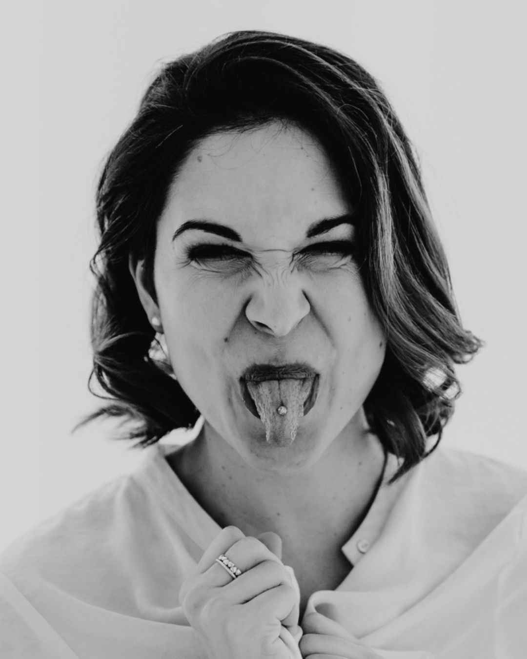 Auf einem Schwarzweissfoto streckt eine Frau ihre Zunge heraus.