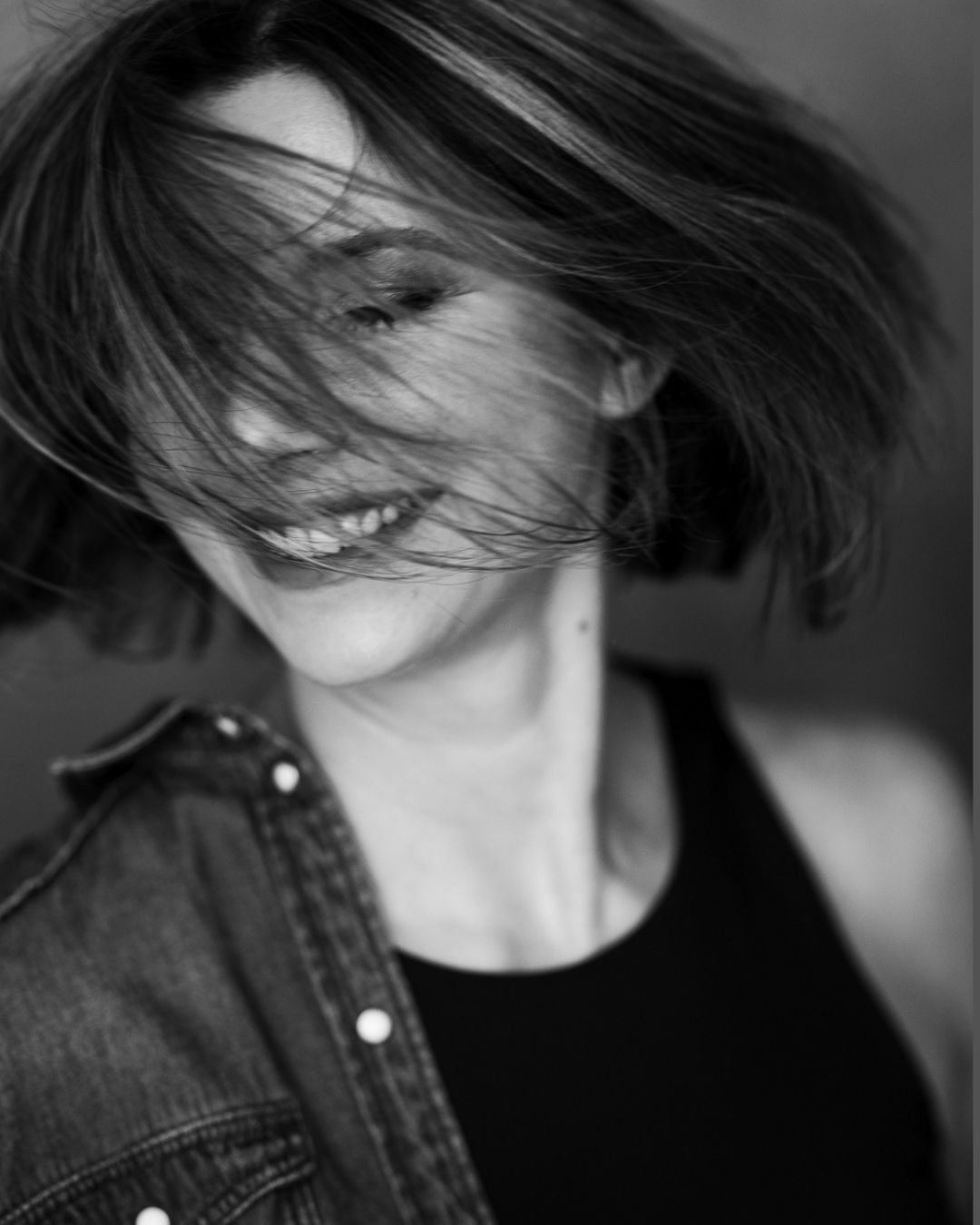 Ein Schwarzweissfoto einer Frau, deren Haare im Wind wehen.