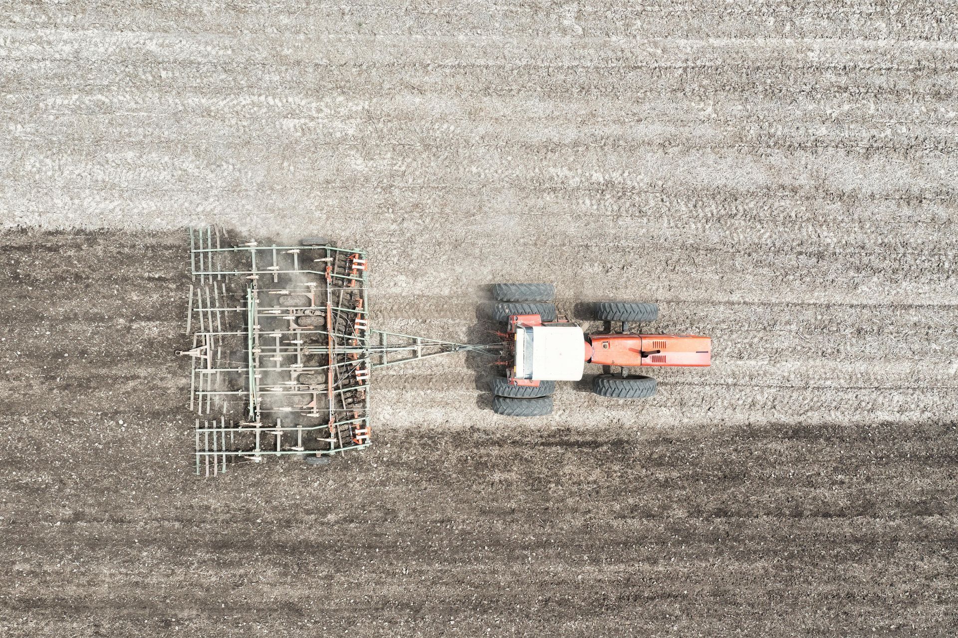 An aerial view of a tractor plowing a field.