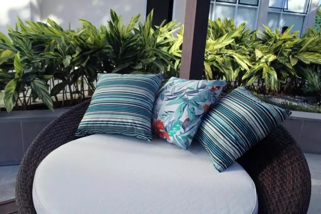 Uma cadeira redonda de vime com almofadas - Best in Rio Stay Convention Suítes