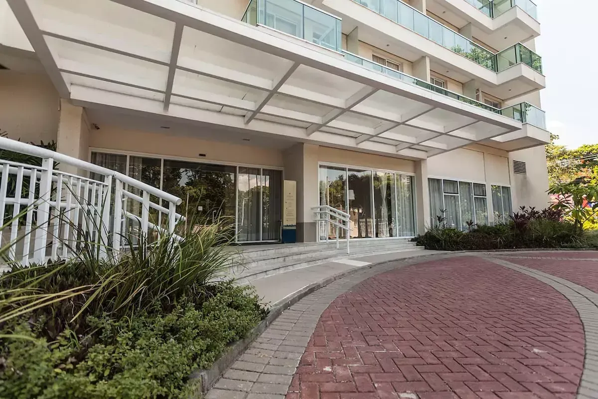 Um grande edifício com uma entrada de tijolos que leva até ele - Best in Rio Stay Convention Suítes