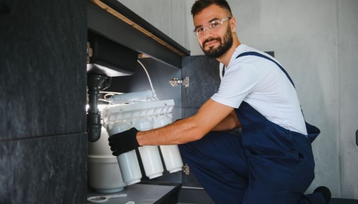 plumber in castle rock performing maintenance repairs on kitchen sink.