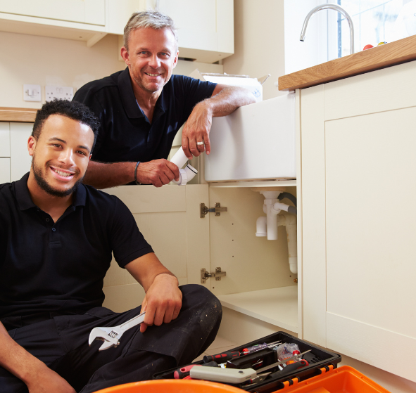 Two plumbers in Westminster, CO are working on repairing a kitchen sink.