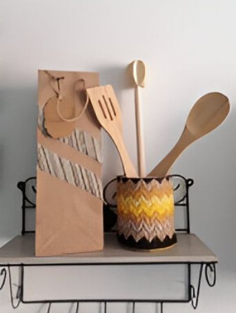 Utensilios de madera en una bolsa marrón en un estante.