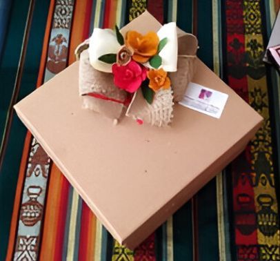 Una caja de cartón con flores y un lazo encima.
