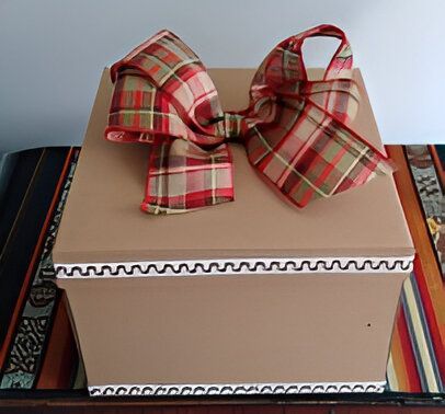 Una caja marrón con un lazo a cuadros encima.