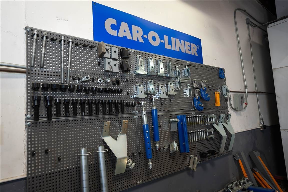 Tools organized on a pegboard in a garage, with a blue 