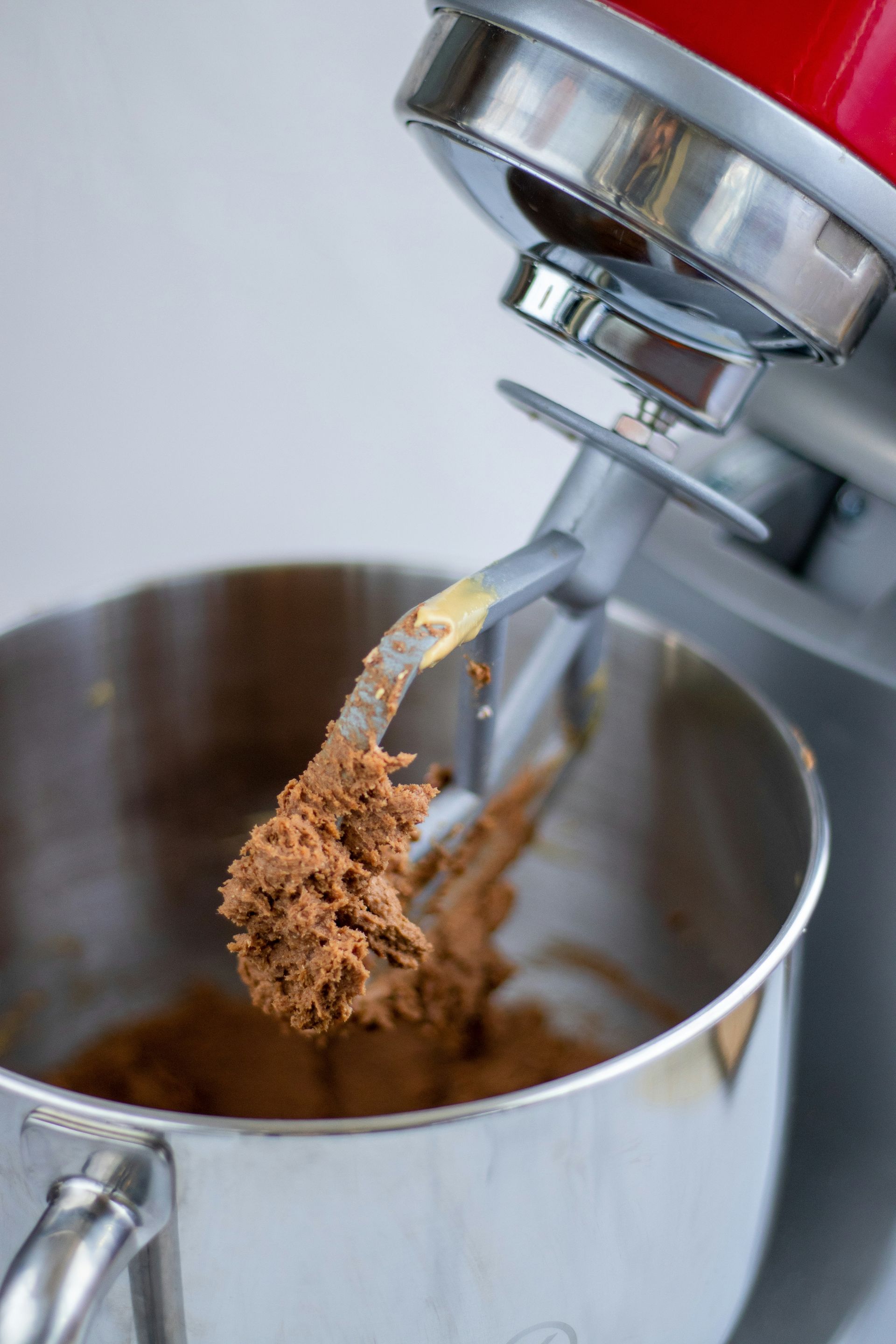 A close up of a mixer with a spoon in it.