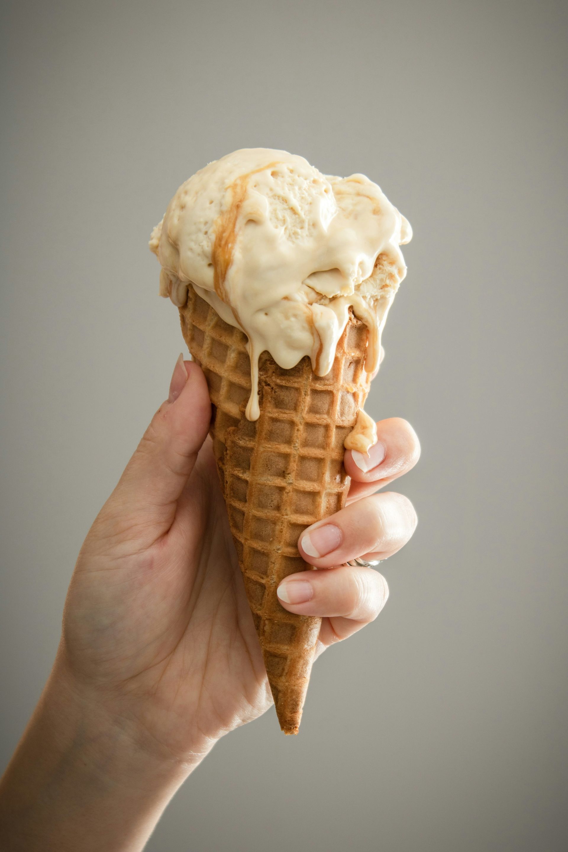 A person is holding an ice cream cone in their hand.