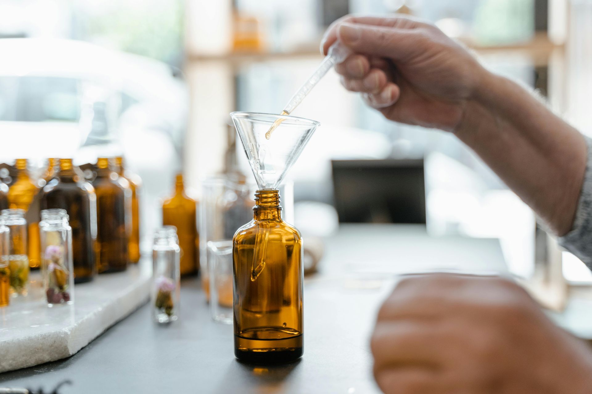 A person is pouring liquid into a bottle with a pipette.