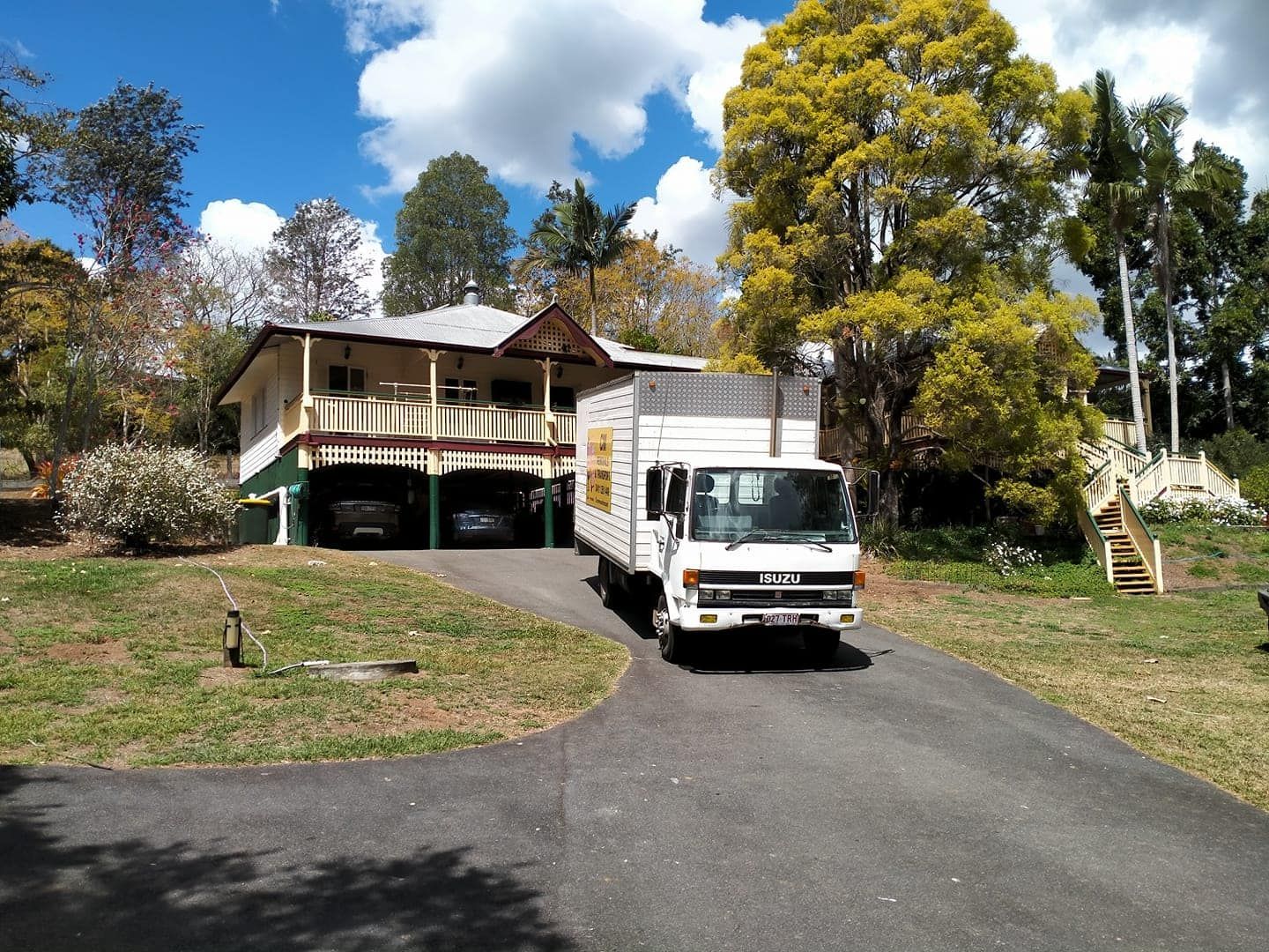 A white truck is parked in front of a house — CM Removals & Transport In Bundaberg, QLD