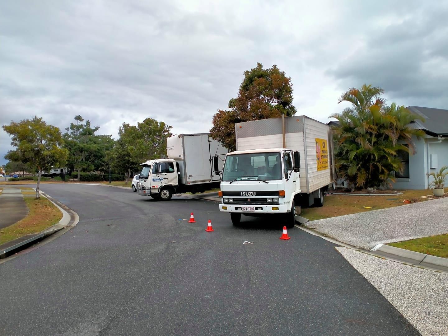 Two moving trucks are parked on the side of the road. — CM Removals & Transport In Bundaberg, QLD