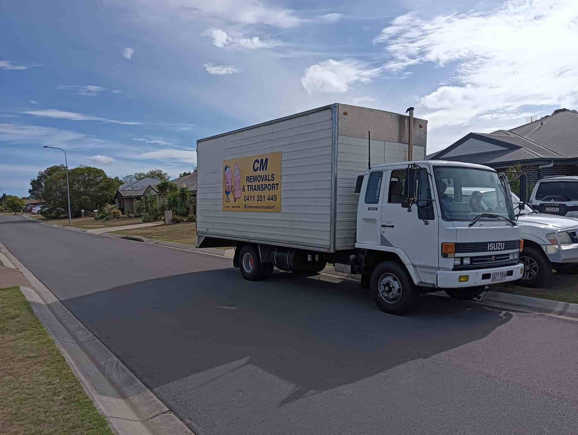 a White Moving Truck is Parked on the Side of the Road — CM Removals & Transport In Maryborough, QLD