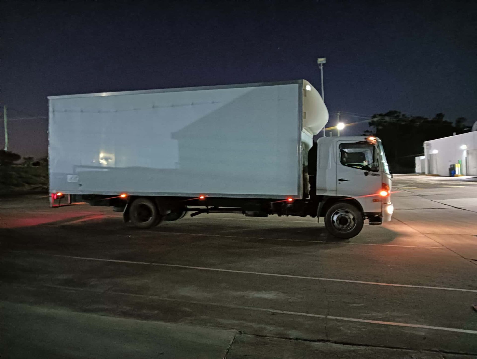 a White Truck is Parked in a Parking Lot at Night — CM Removals & Transport In Tin Can Bay, QLD