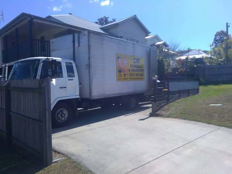 a White Moving Truck is Parked in Front of a House — CM Removals & Transport In Gympie, QLD